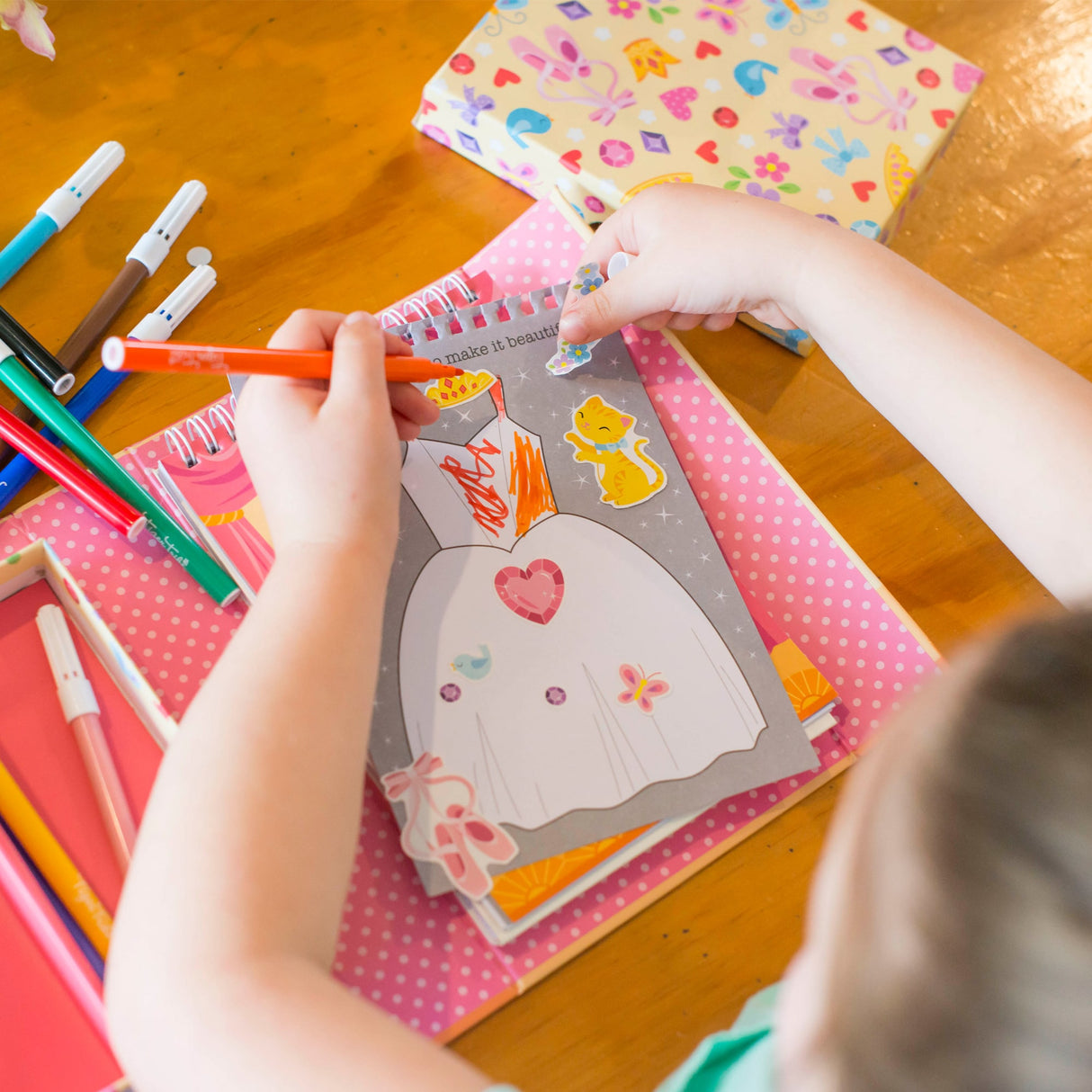 Child colors a ballet dress coloring page with crayons for Schylling 14014