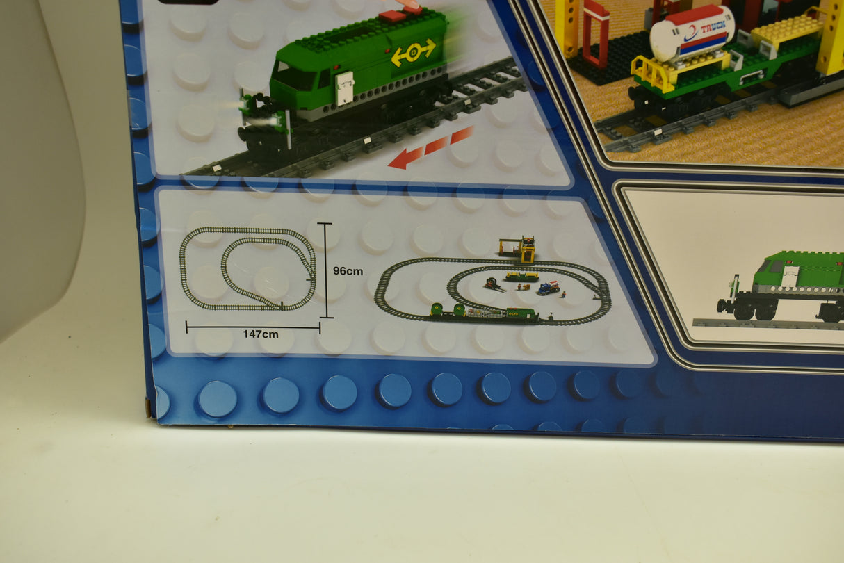 Train set layout showing green diesel freight train, crane, and track pieces for Electric Train AUS25121