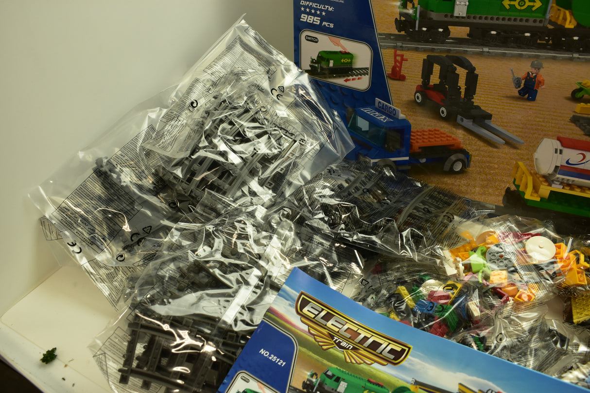 Assorted train track and accessory pieces in clear packaging for Electric Train AUS25121