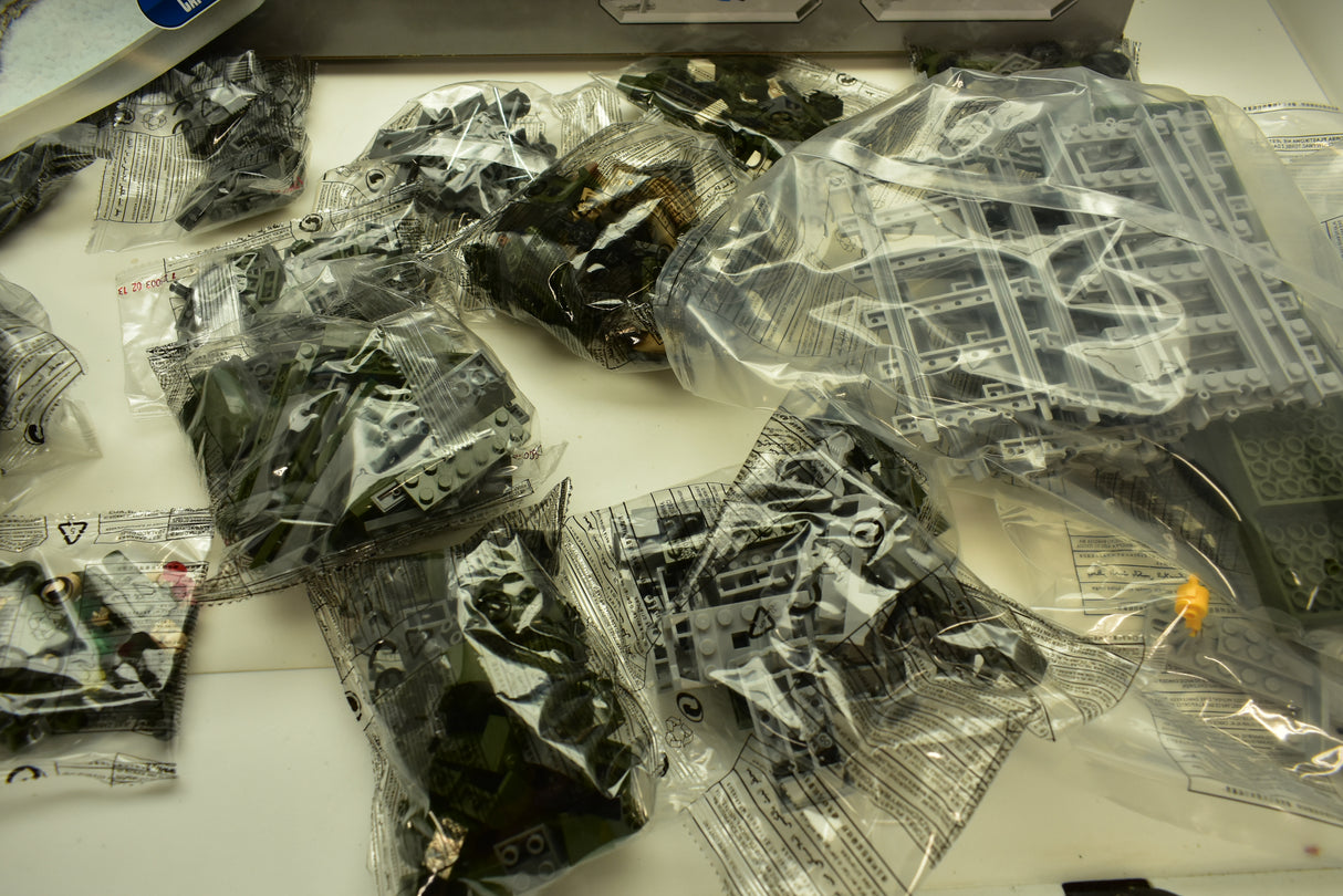 Assorted plastic train track and vehicle pieces in clear bags for Railroad Conveyance Trains AUS25003