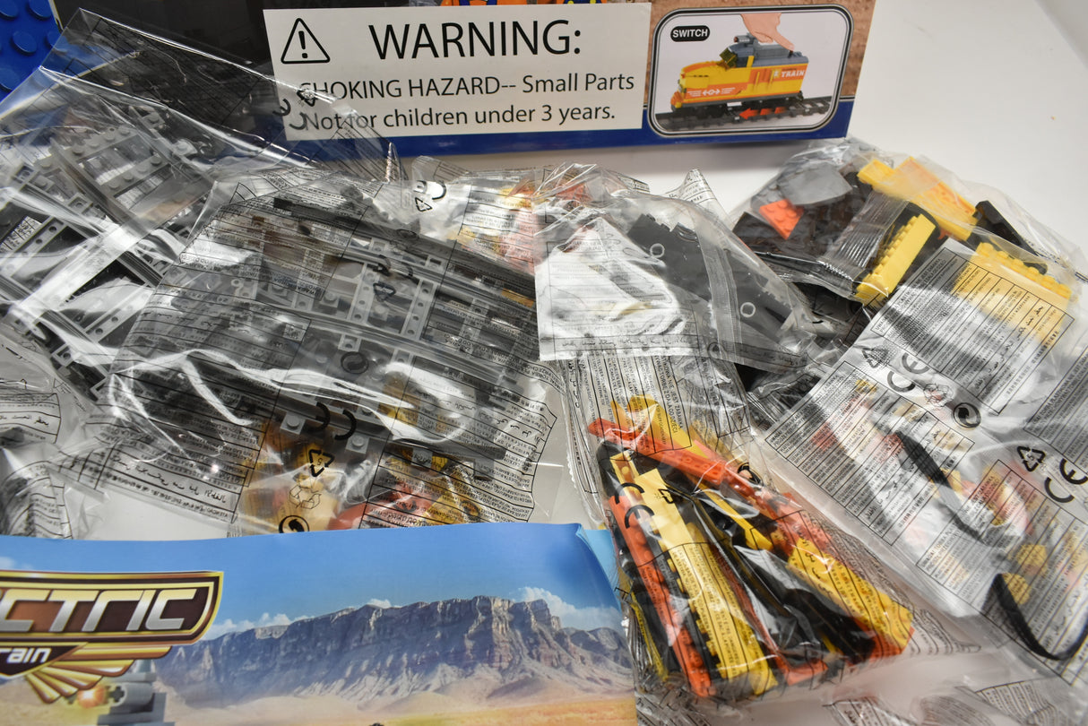Train parts in plastic bags with a warning label for Electric Train AUS25827