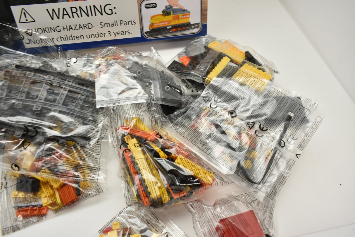 Toy train parts in clear plastic packaging, including a diesel switcher for Electric Train AUS25827