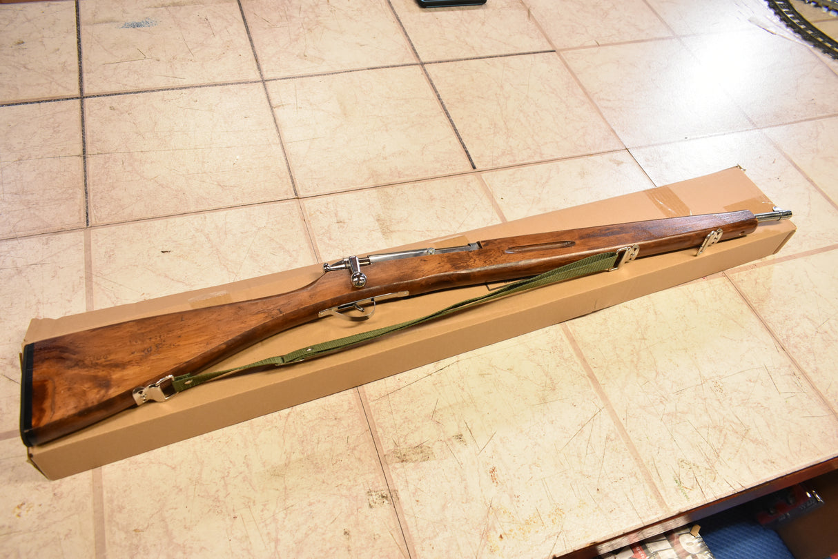 Wooden trainer rifle in a cardboard box on a tiled floor for Parris Toys M-30b Trainer Rifle