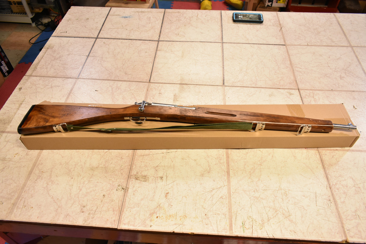 Wooden trainer rifle lying on a light-colored table surface for Parris Toys M-30b Trainer Rifle