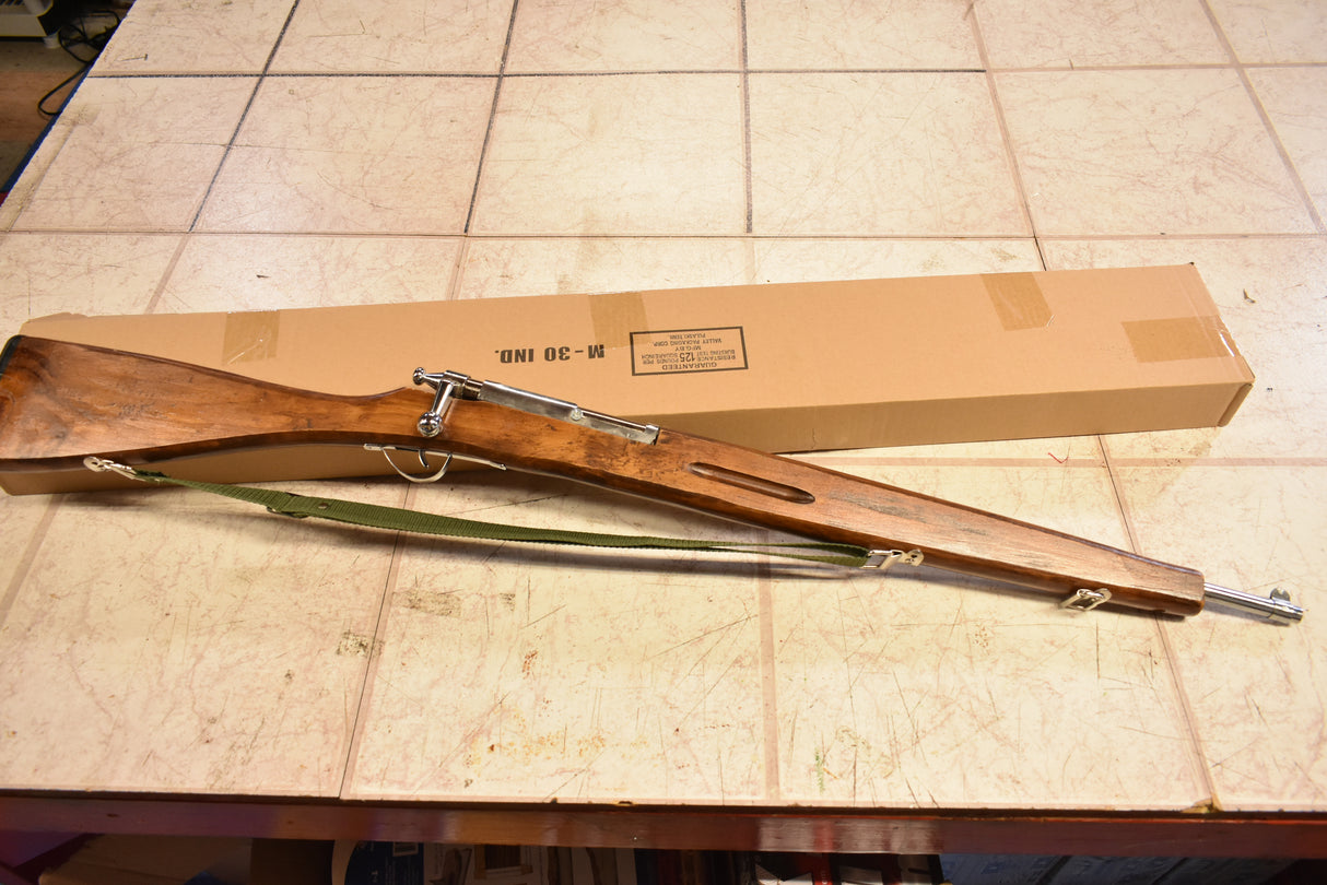 Wooden trainer rifle with sling, resting on a box labeled M-30 IND for Parris Toys M-30b Trainer Rifle