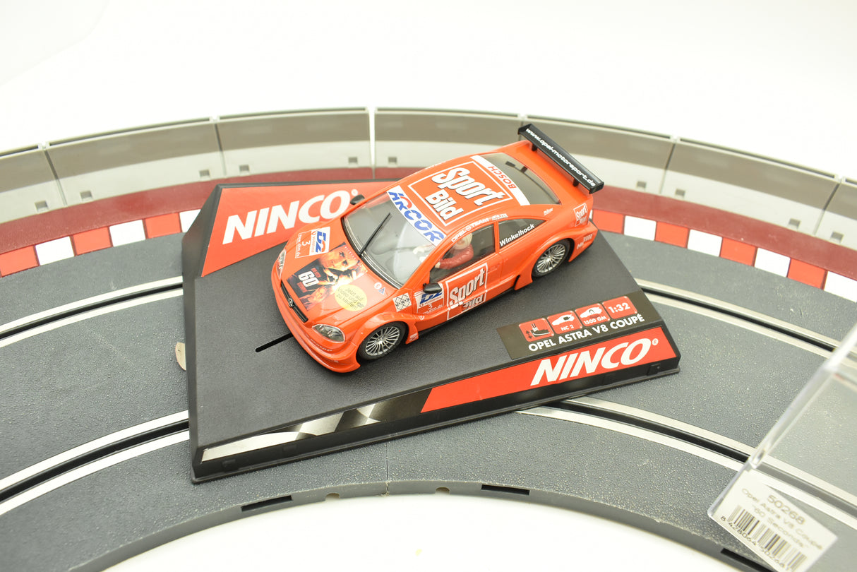 Orange slot car on black base with "Opel Astra V8 Coupe" text for Ninco 50268