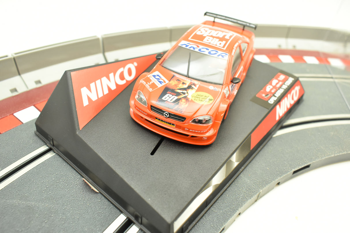 Orange race car on black track piece, representing an Opel Astra V8 Coupe for Ninco 50268