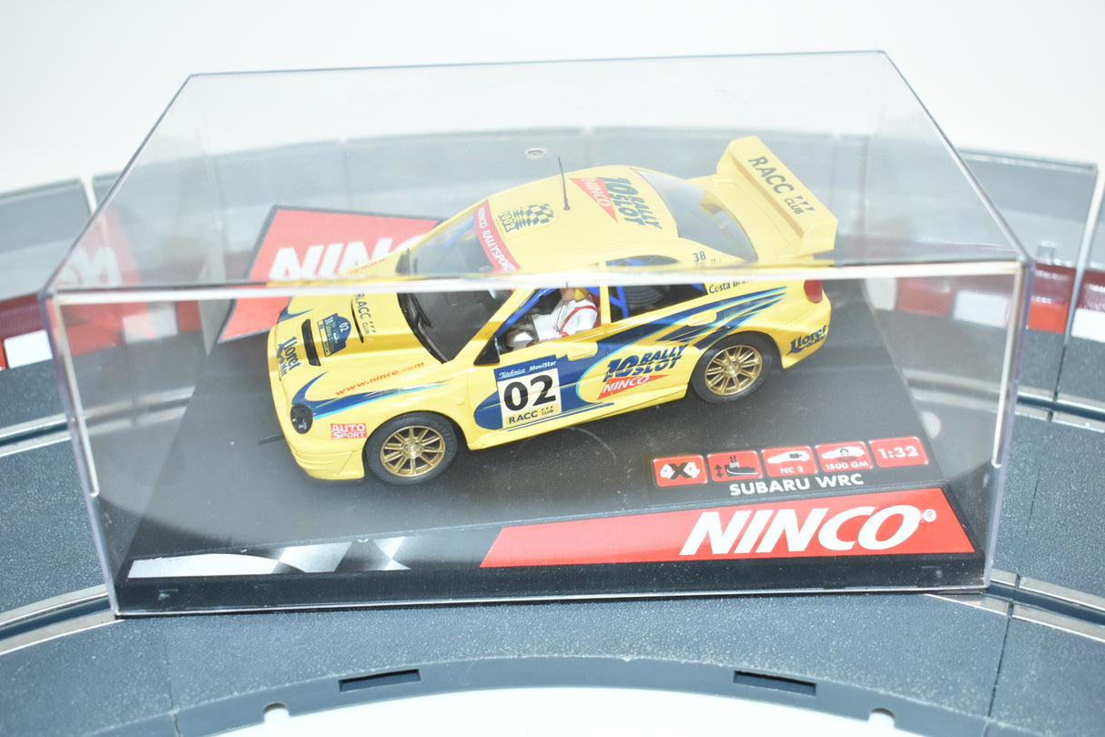 Yellow Subaru WRC slot car in clear display case for Ninco 50257