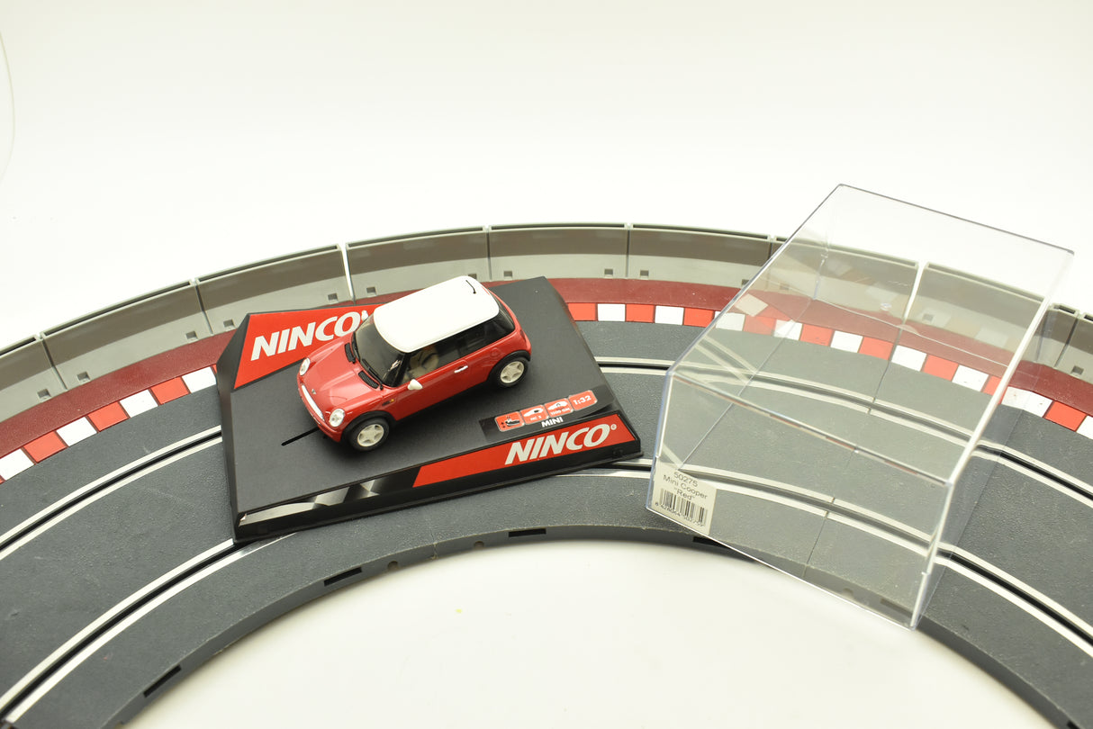Red and white Mini Cooper toy car on a black track piece for Ninco 50275