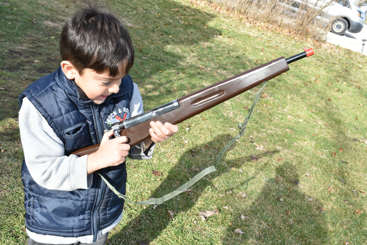 Boy holding a replica rifle outdoors on green grass for Parris Toys K-21B