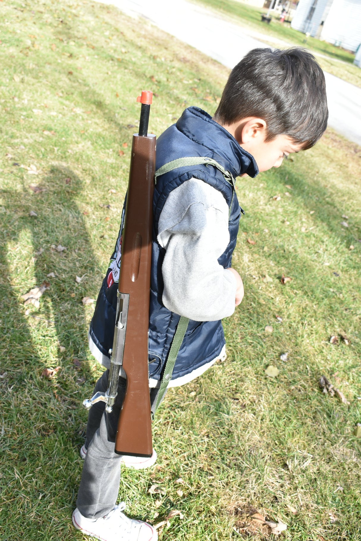 Boy with brown replica rifle standing on green grass outdoors for Parris Toys K-21B