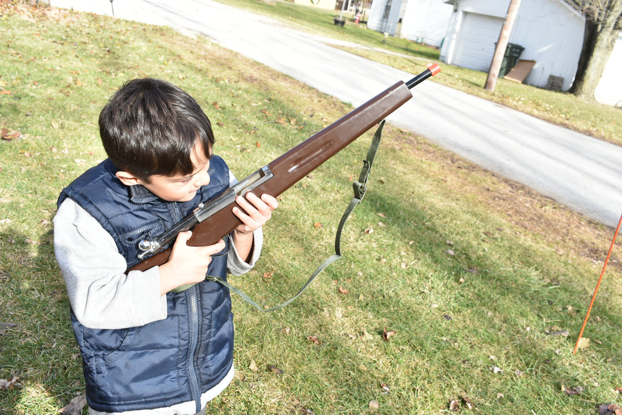 Boy holding a replica rifle outdoors on a grassy lawn for Parris Toys K-21B