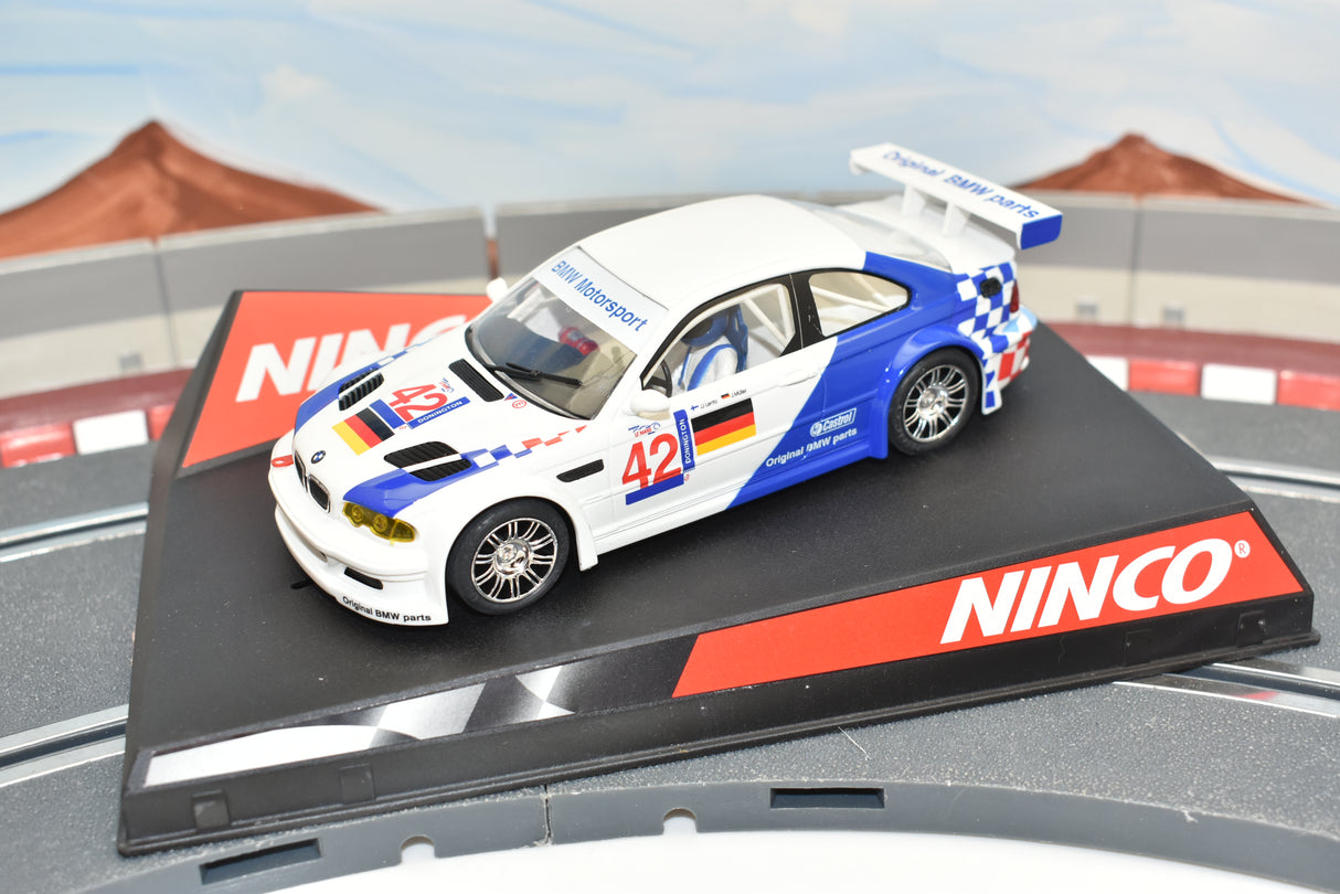 White and blue BMW race car model on a track base for Ninco 50270