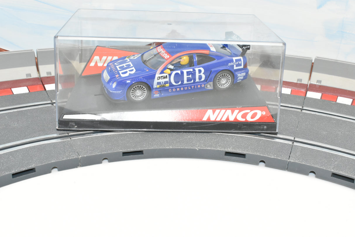Blue Mercedes race car in clear display case on track section for Ninco 50287