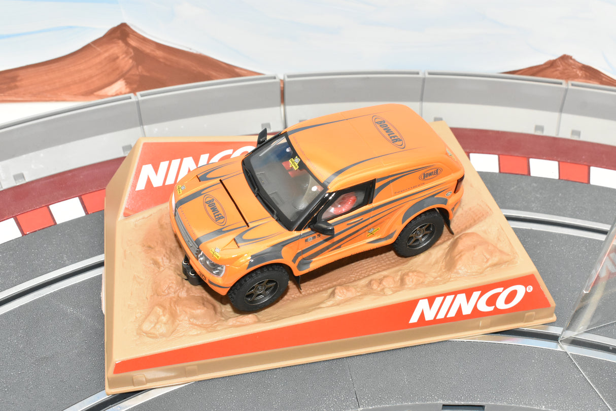 Orange toy car on a display base, representing a race car model for Ninco 50508