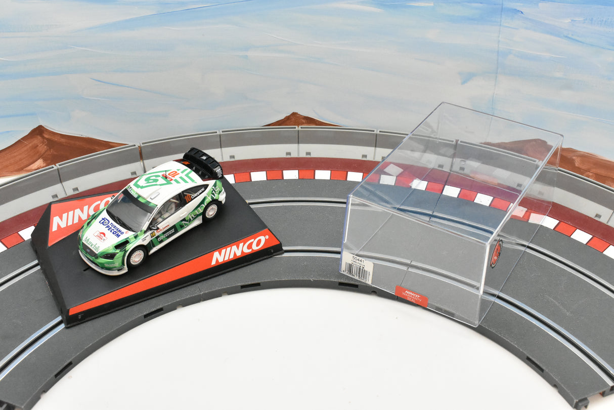 Green Ford Focus race car on a track with clear barrier for Ninco 50441