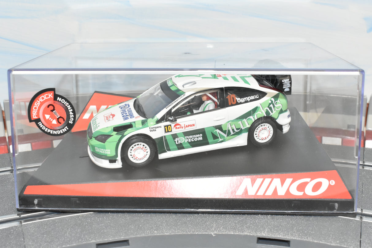 Green and white Ford Focus race car model on a display base for Ninco 50441