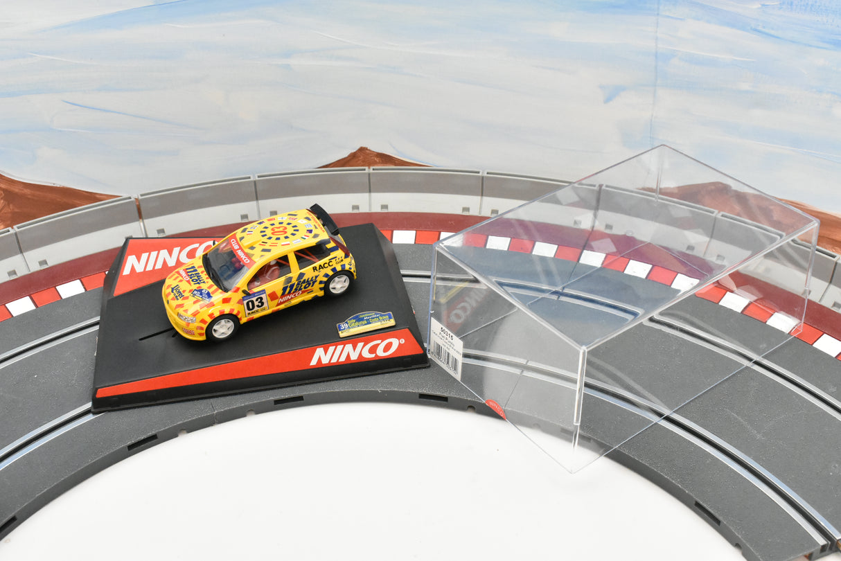 Yellow race car on a track section with a clear display case for Ninco 50315