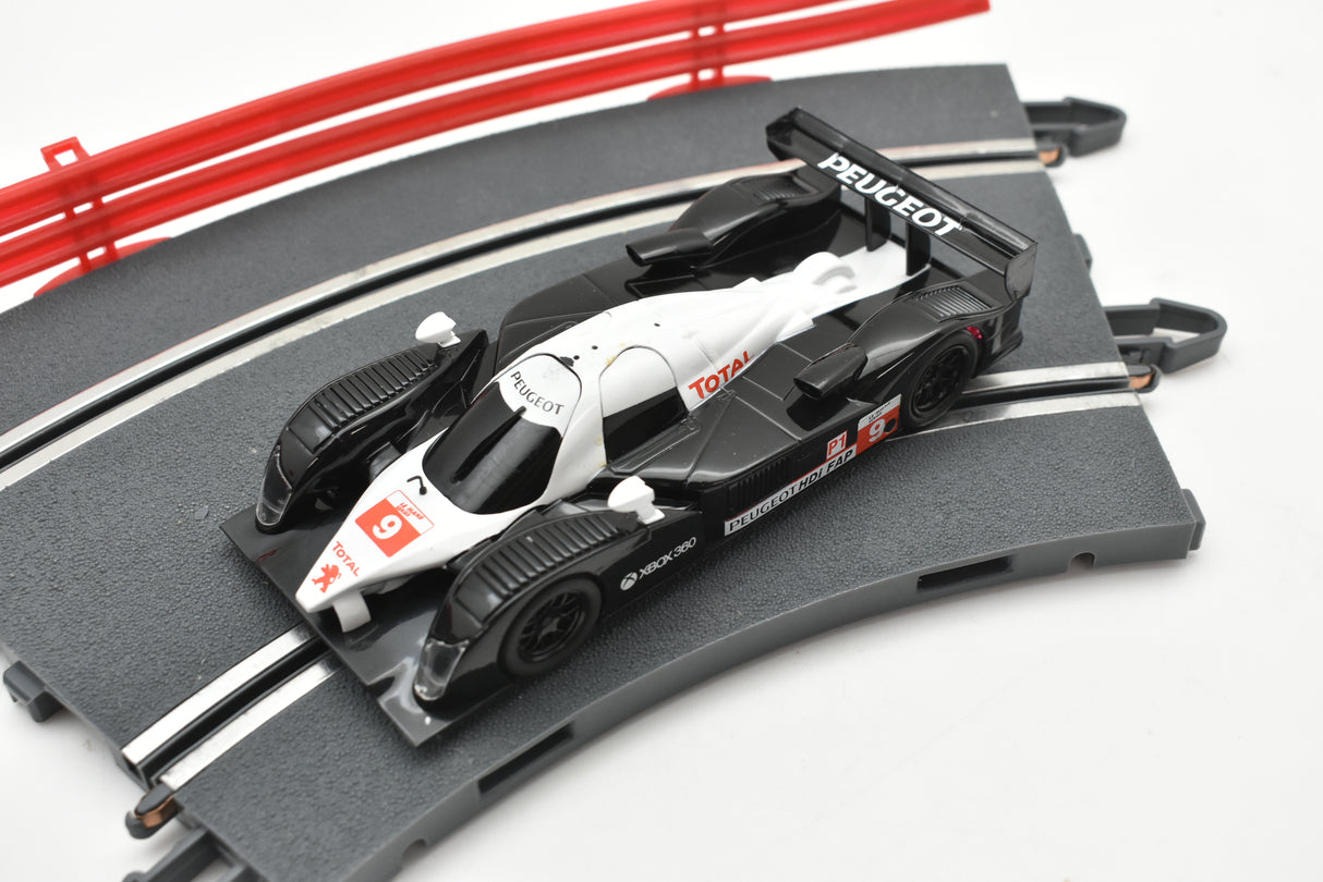 Black and white slot car replica of a Peugeot 908 HDI FAP race car for SCX A10300X3U0, front view