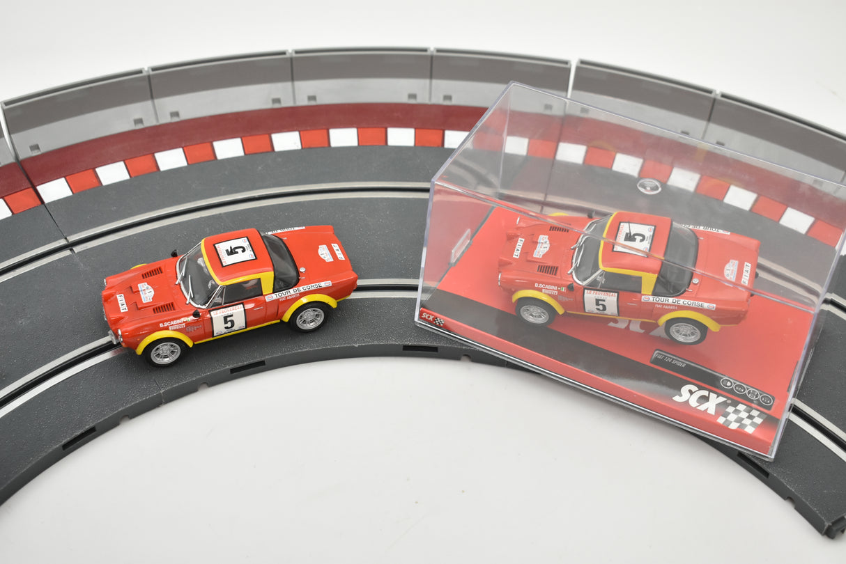 Two red slot car replicas on a curved track section for SCX A10220X3U0
