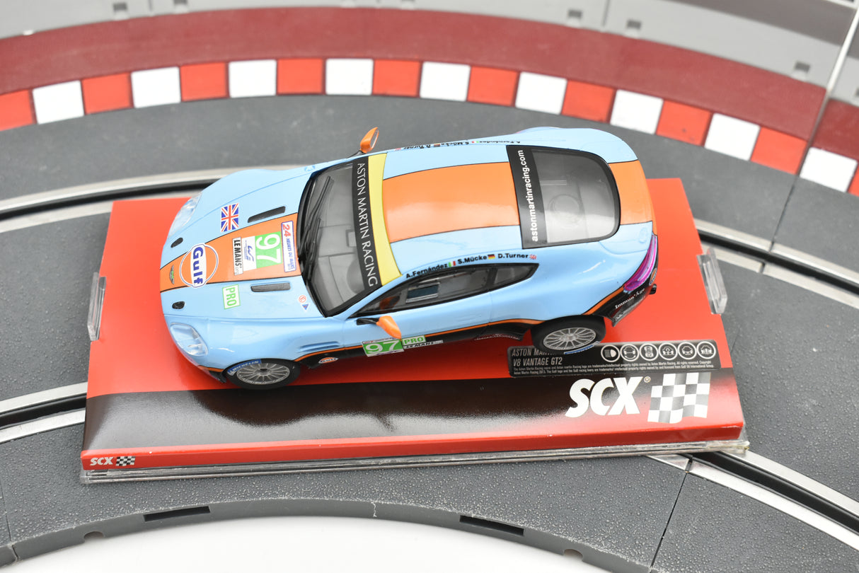 Blue and orange Aston Martin Vantage race car on a track section for SCX A10116X3U0