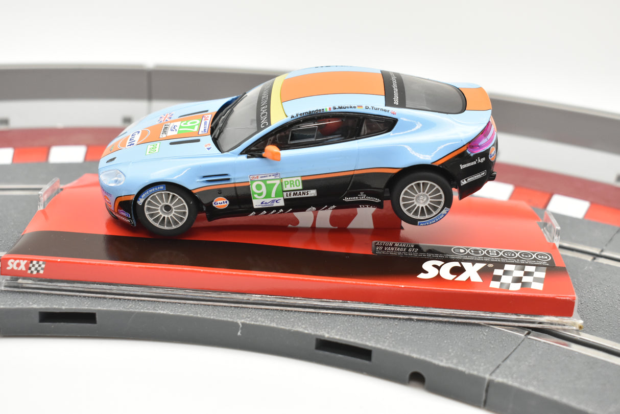 Blue and orange Aston Martin race car on a track section for SCX A10116X3U0