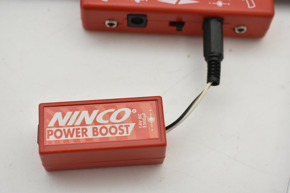 Red power boost module with attached black electrical connector for Ninco 10304