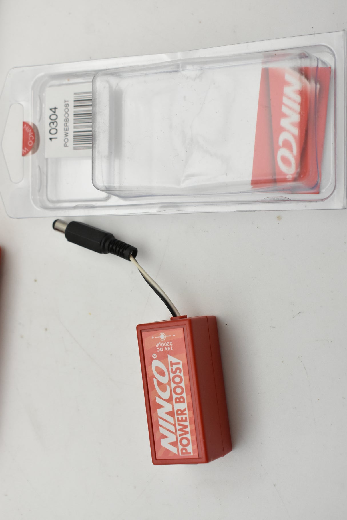 Small red power supply unit with attached black cord for Ninco 10304