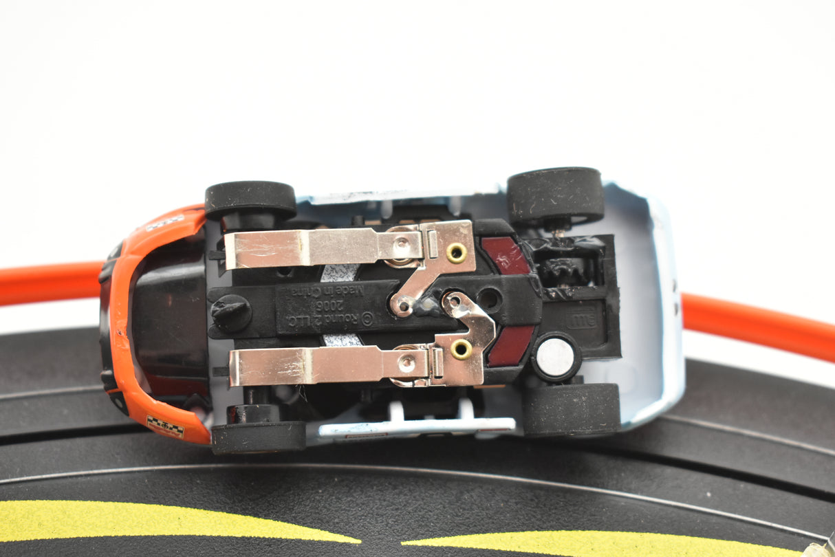 View of a slot car toy car's undercarriage, showing internal mechanics for Auto World SC0006