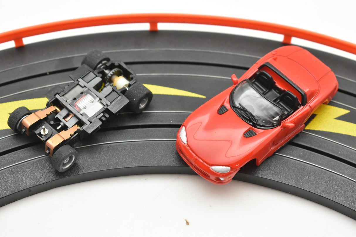 Red convertible toy car and black track section with a black/gold stripe for Tyco B15043