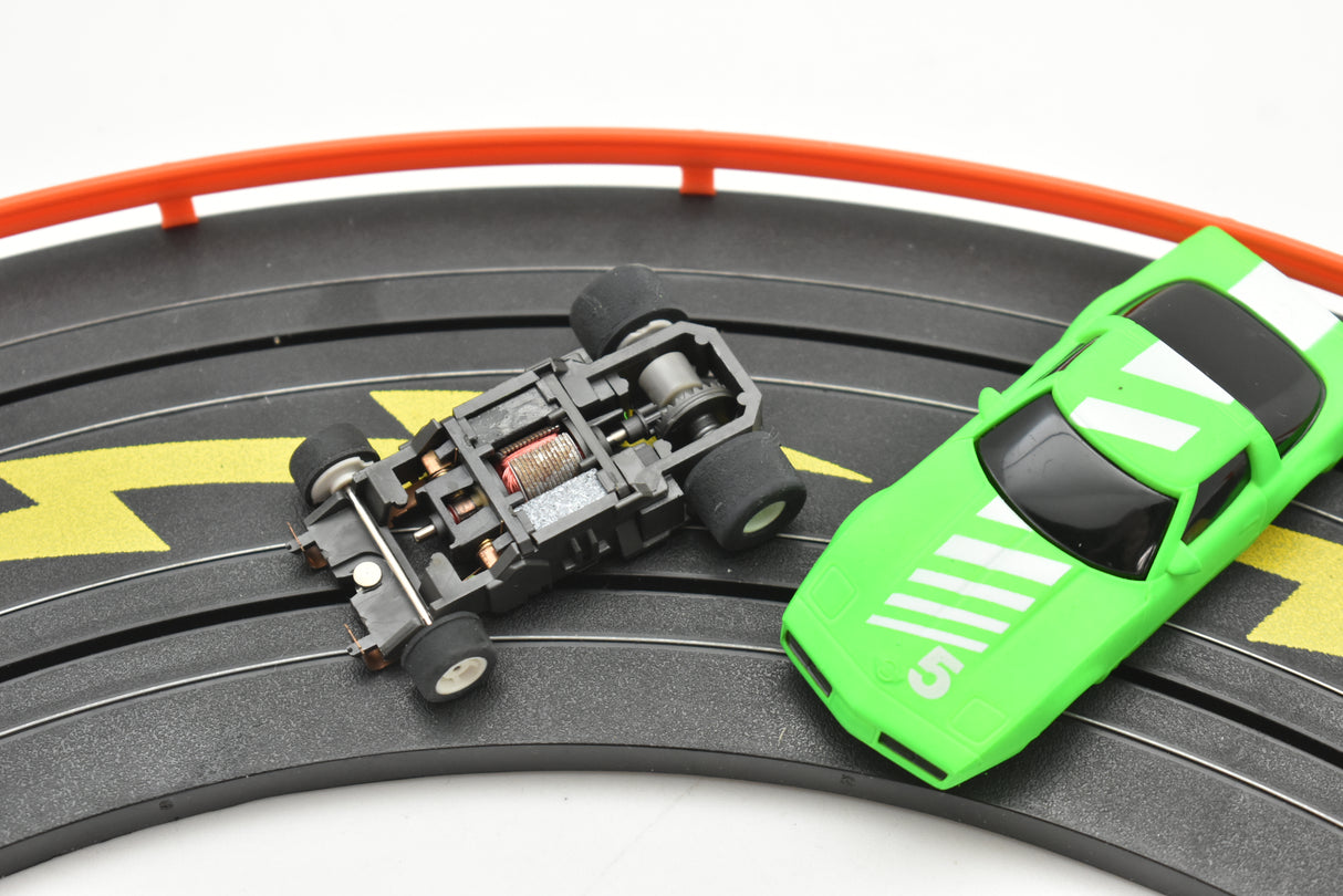 Green and black toy race cars on a track for Tyco B7057