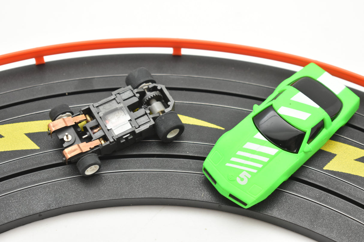 Toy race car and small black car on a track for Tyco B7057