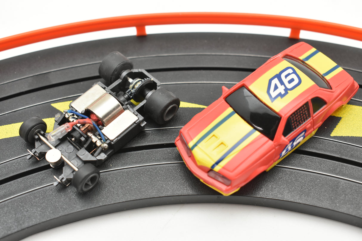 Red and yellow NASCAR car with lights on a black track for Life-Like 13017B