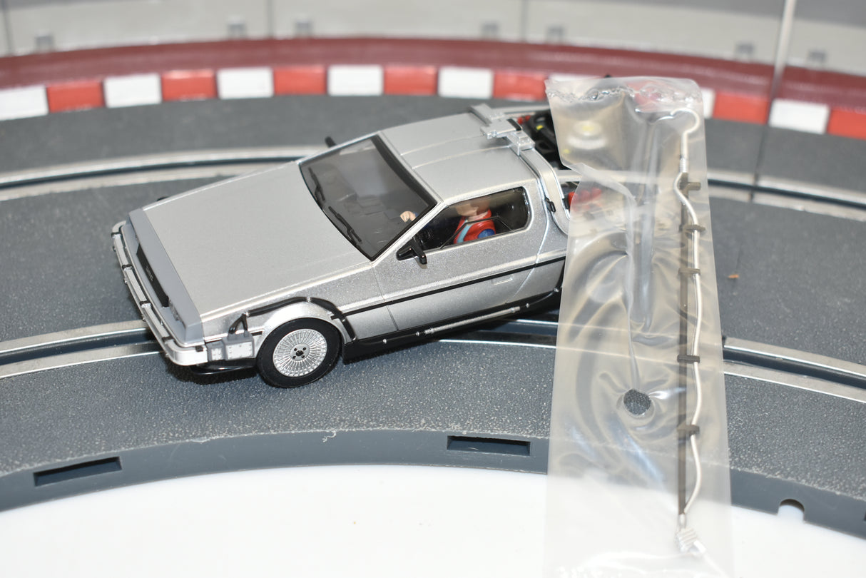 Silver DeLorean model car on a track section, packaged in plastic for Scalextric C4117