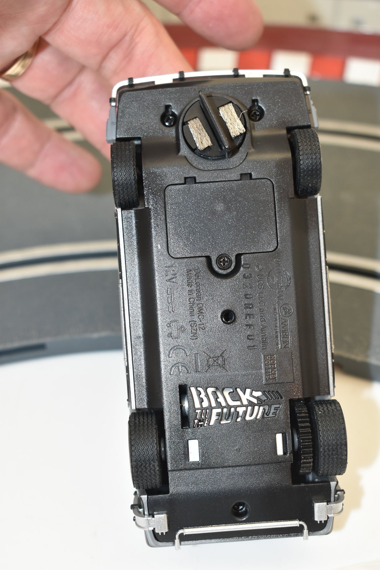 Black model train car accessory for DeLorean, showing electrical contacts for Scalextric C4117