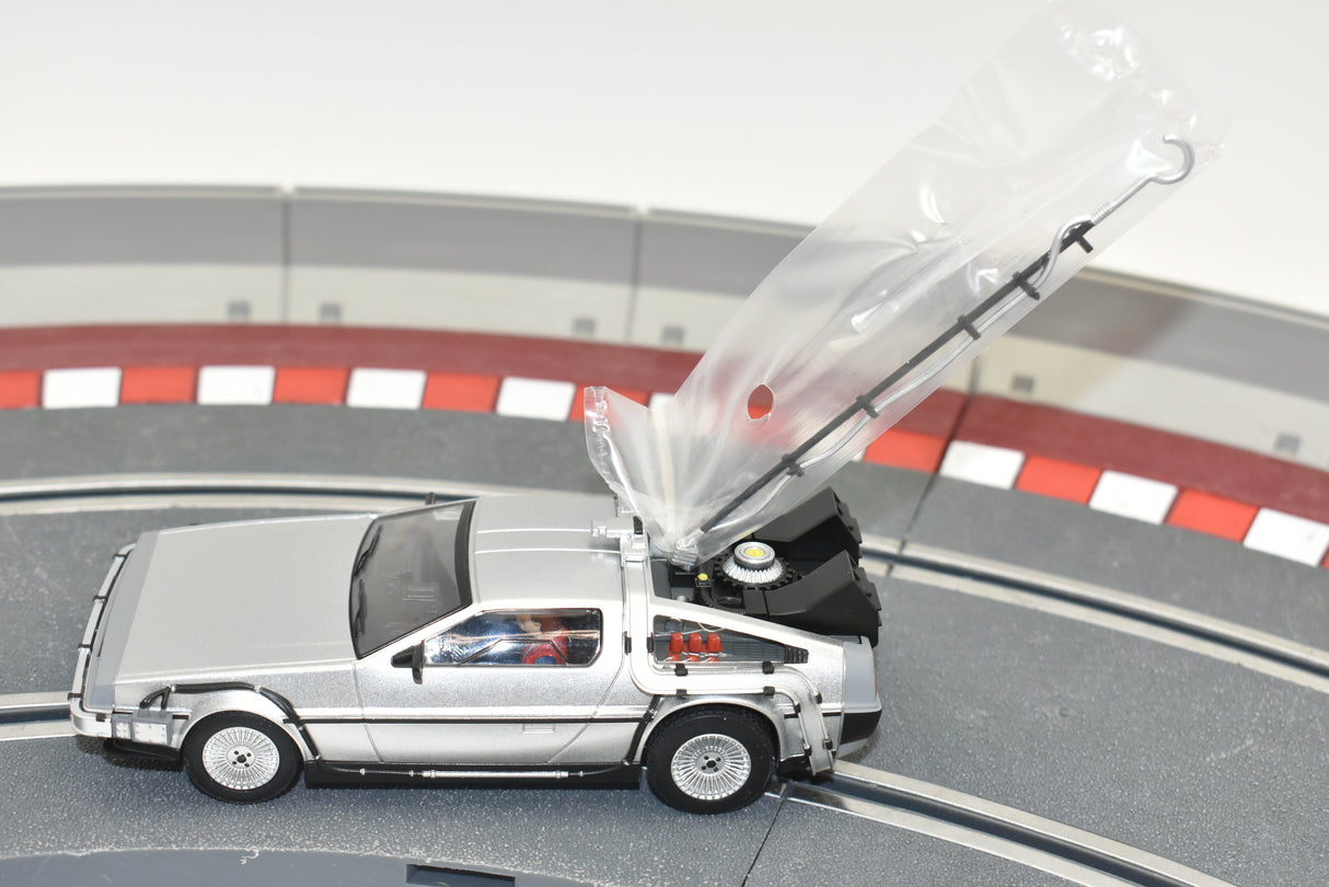 Silver DeLorean toy car with open gullwing door on a track for Scalextric C4117