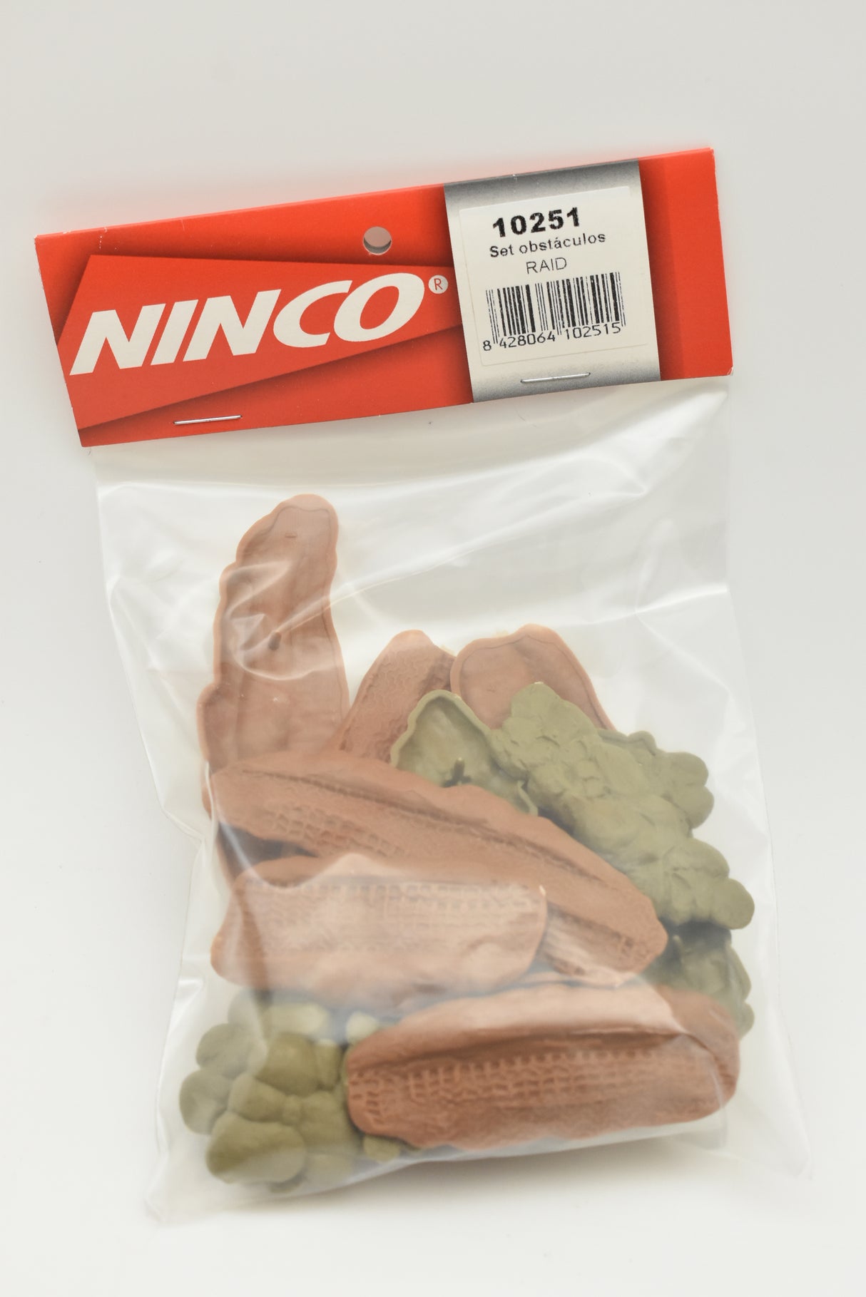 Assortment of brown and green plastic off-road obstacles in a clear bag for Ninco 10251, front view