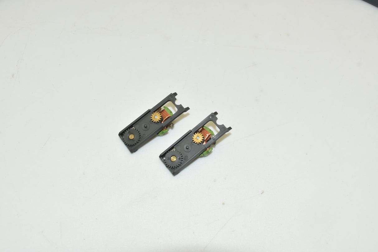 Two black top plate assemblies with gears for a model train for Aurora AFX 1750-061