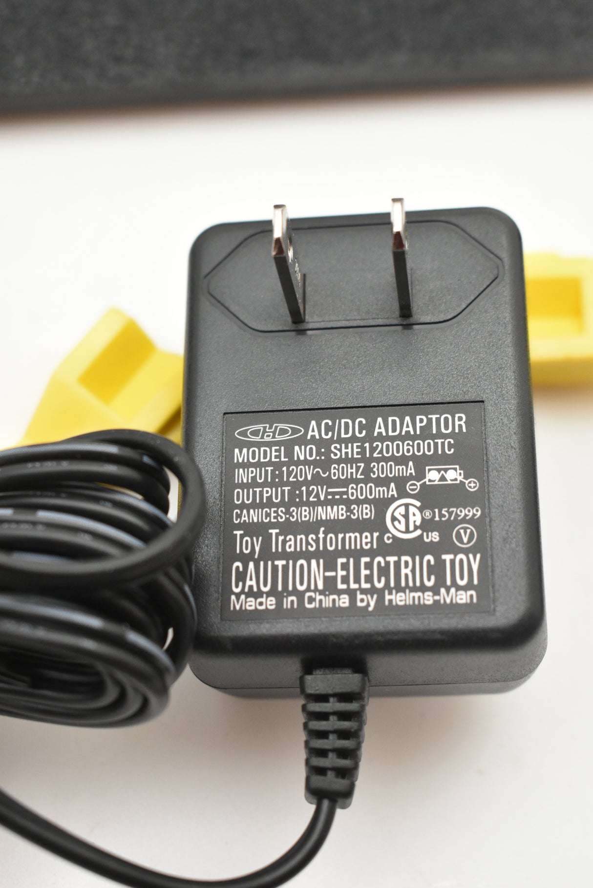 Black AC/DC adapter with prongs and attached cord for a toy kit for SCX Compact SC-01.050