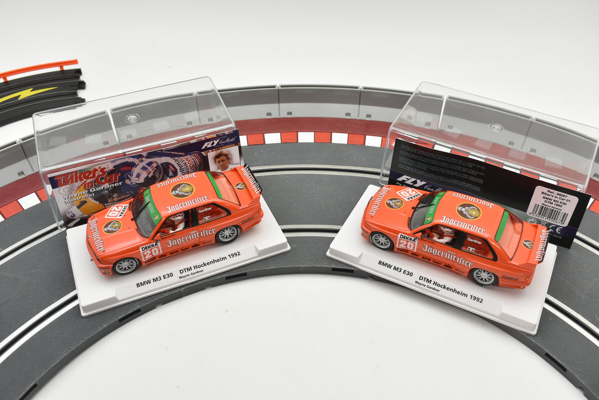 Two slot car BMW M3 E30 race cars displayed on a track section for Fly Car Biker’s In Car 01