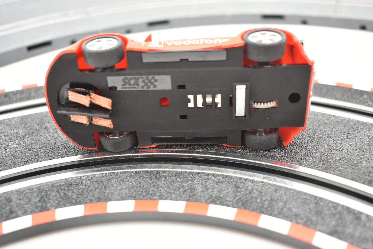 Red remote-control car on a track surface for SCX Compact C10183X300