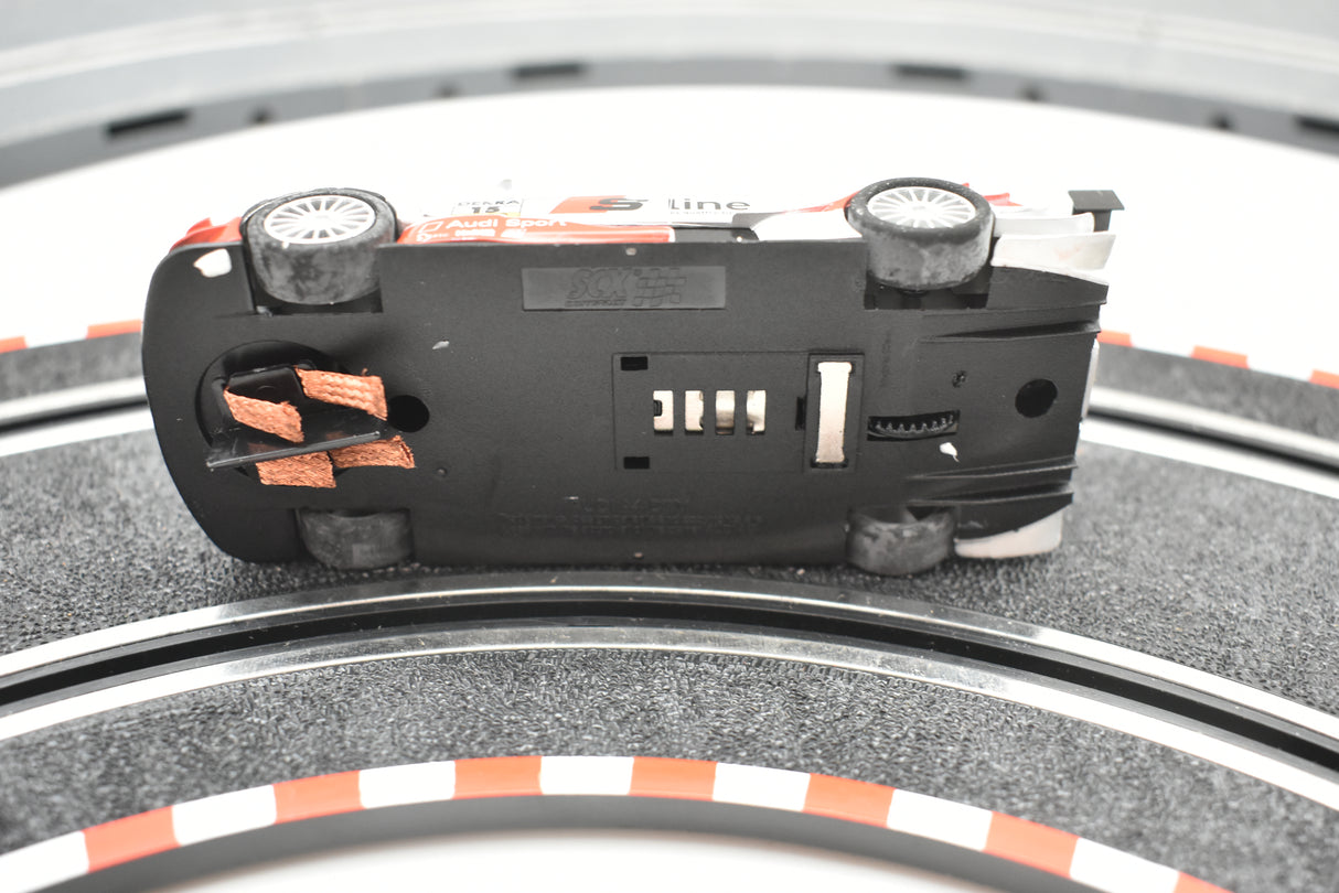 Black electronic device with silver accents, resting on a tire tread surface for SCX Compact C10184X300