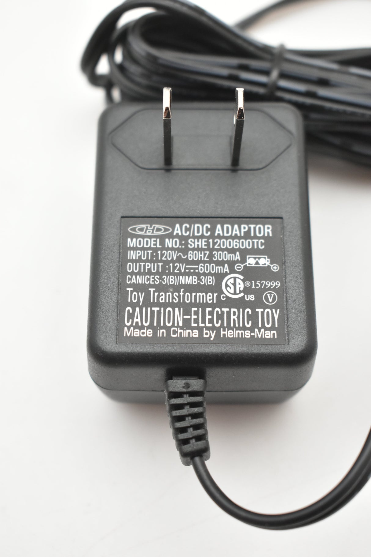 Black AC/DC adapter with prongs and attached cord for SCX Compact SHE1200600TC