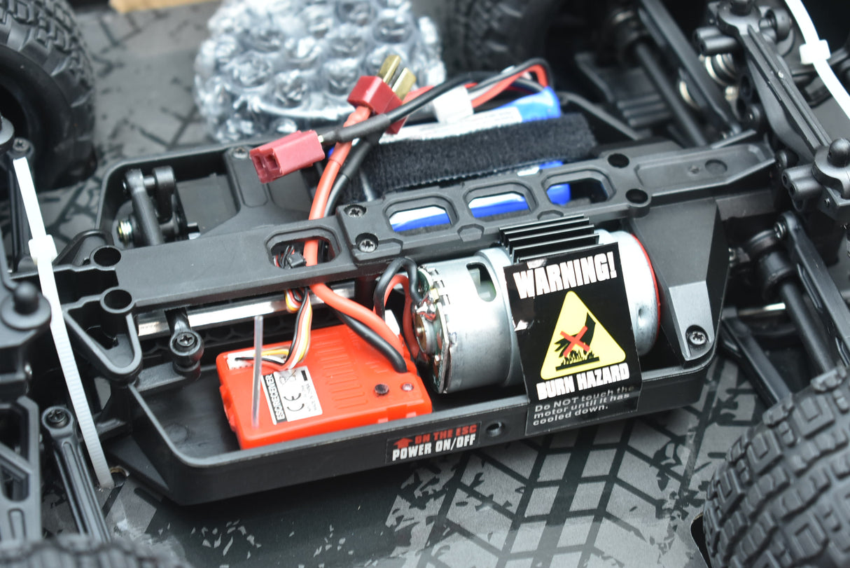 RC truck electronics showing battery, ESC, and motor components for ORANGE/GREEN IMX19025, rear view