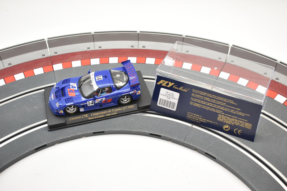 Blue Corvette race car model on a track section with packaging for Fly Car A128