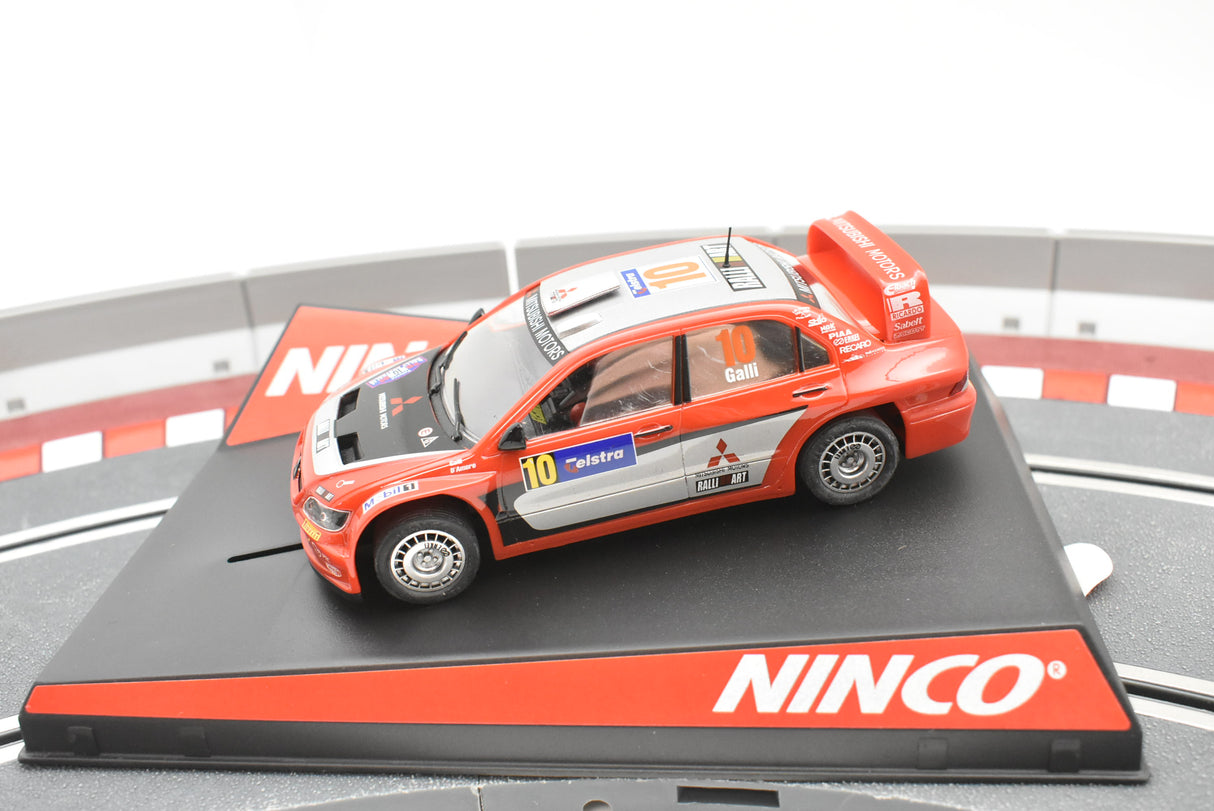 Red and silver slot car of a 2006 Mitsubishi Lancer WRC car for Ninco 50378