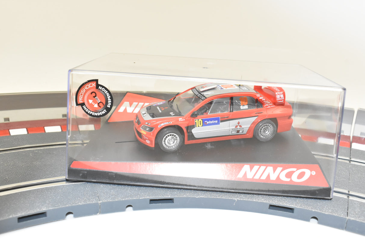 Red Mitsubishi Lancer WRC car on a track base for Ninco 50378