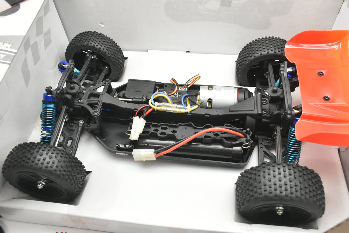 RC buggy chassis with motor, wheels, and suspension components laid out for IMEX 18020