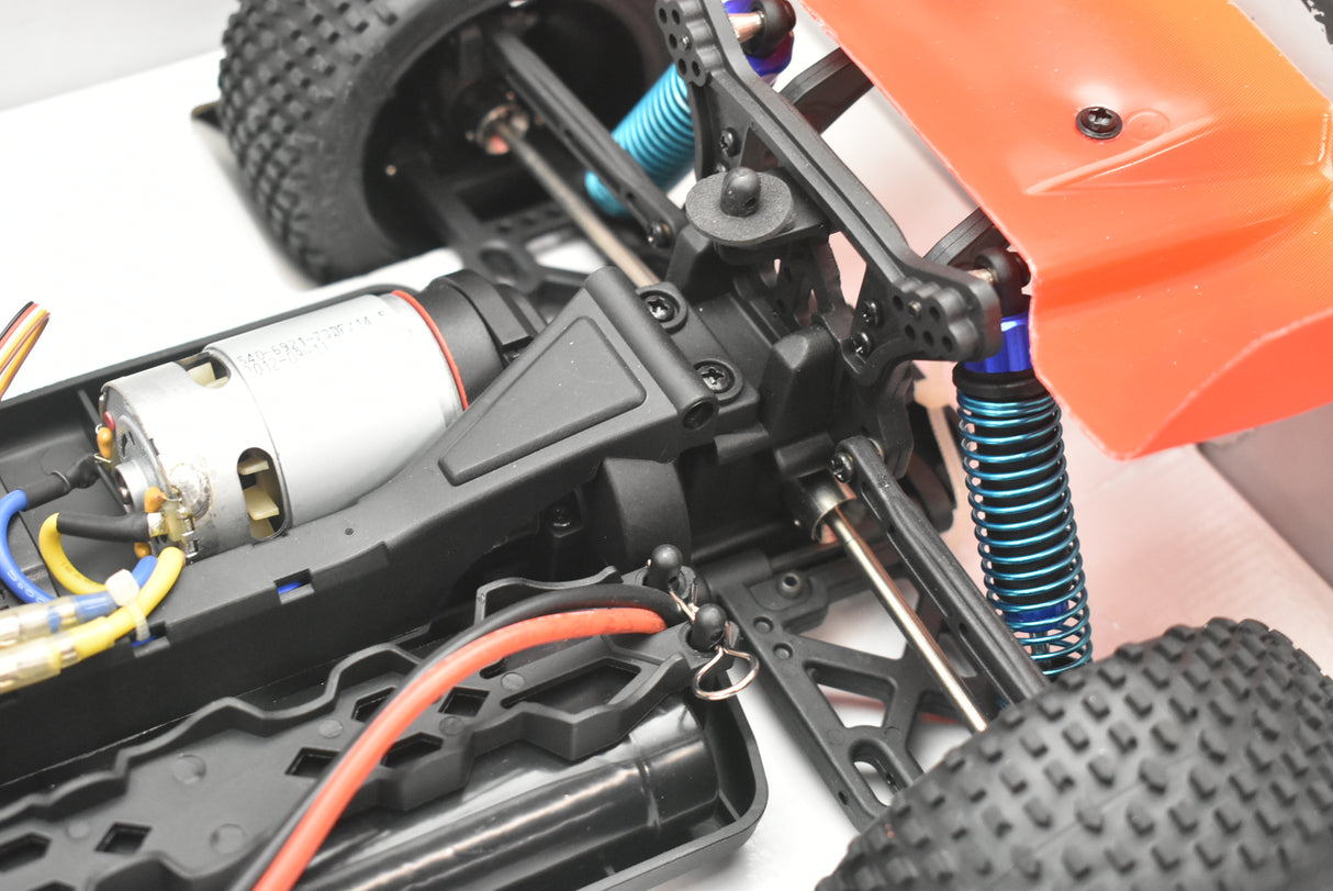 RC buggy chassis with motor, suspension, and tires visible for IMEX 18020