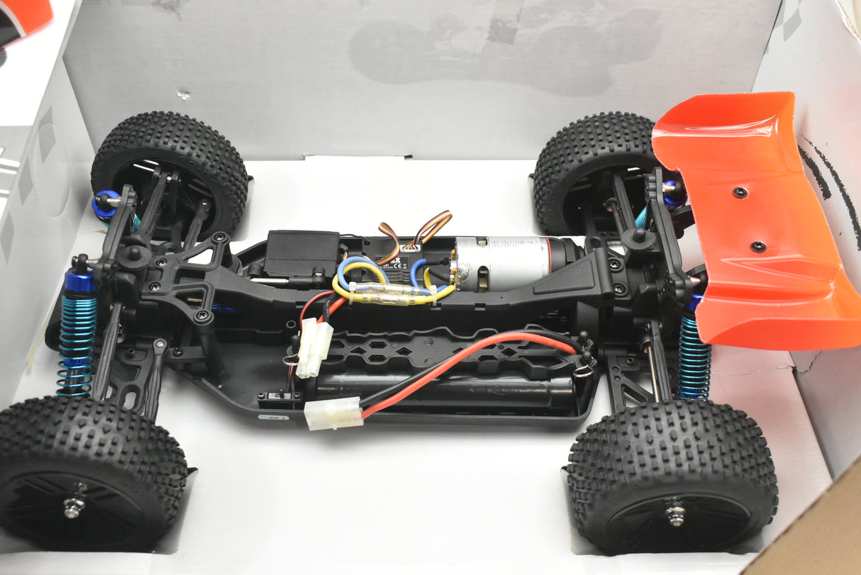 RC buggy chassis with wheels, motor, and orange body shell for IMEX 18020